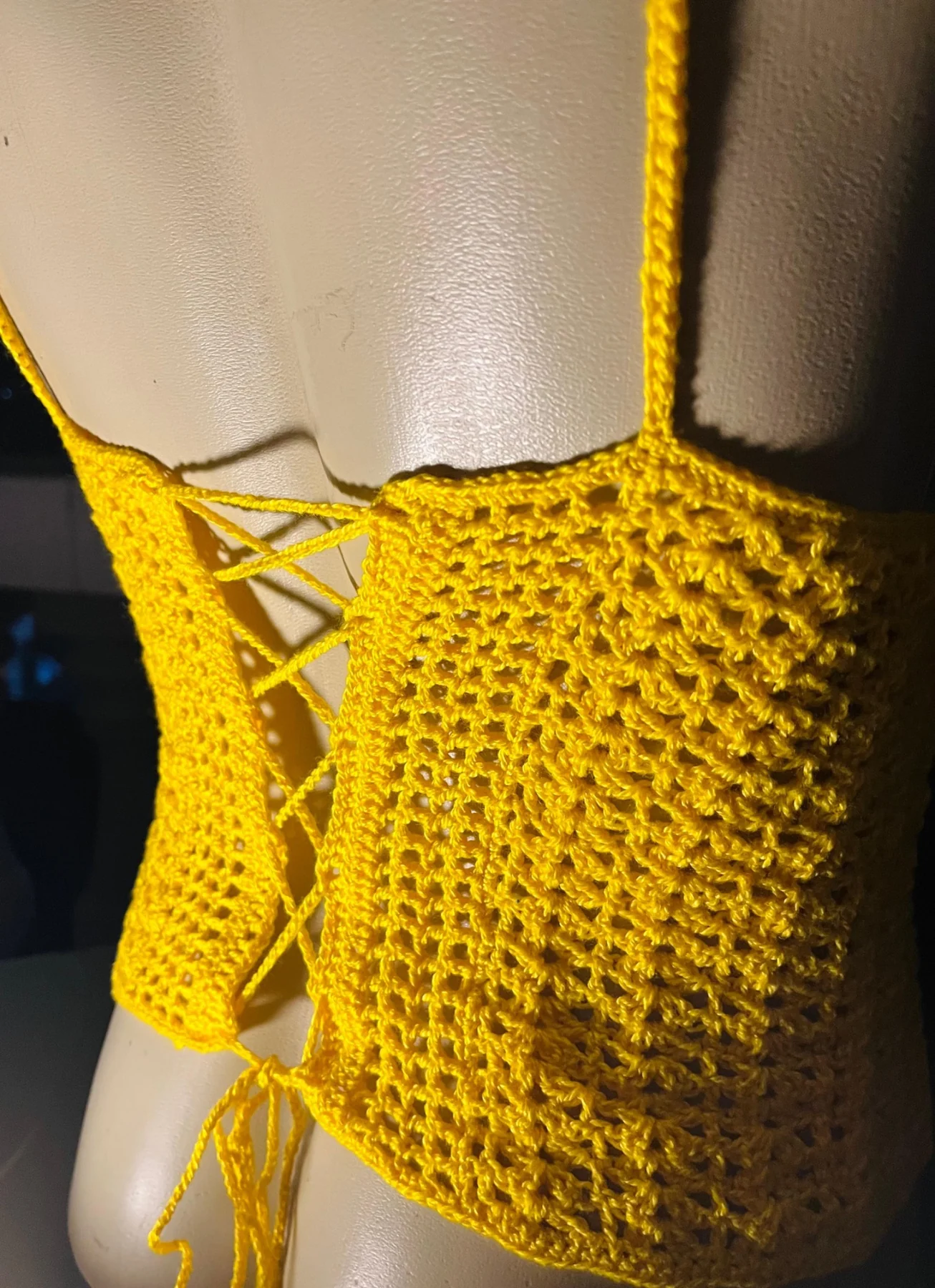 Detalhe de top amarelo em crochê